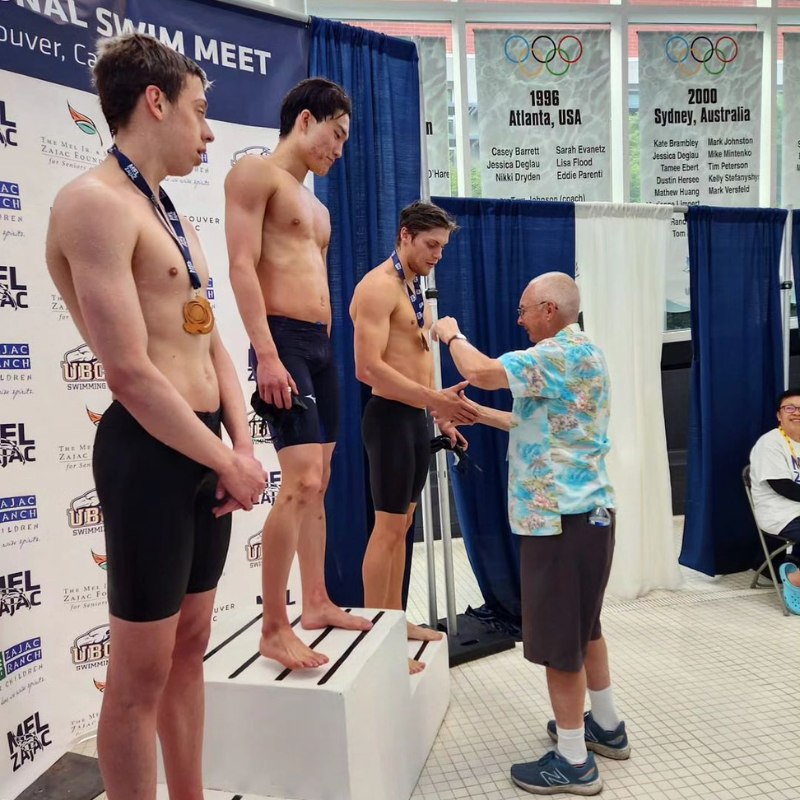 Team Aquatic Supplies Owner Doug Perks handing medals to swimmers